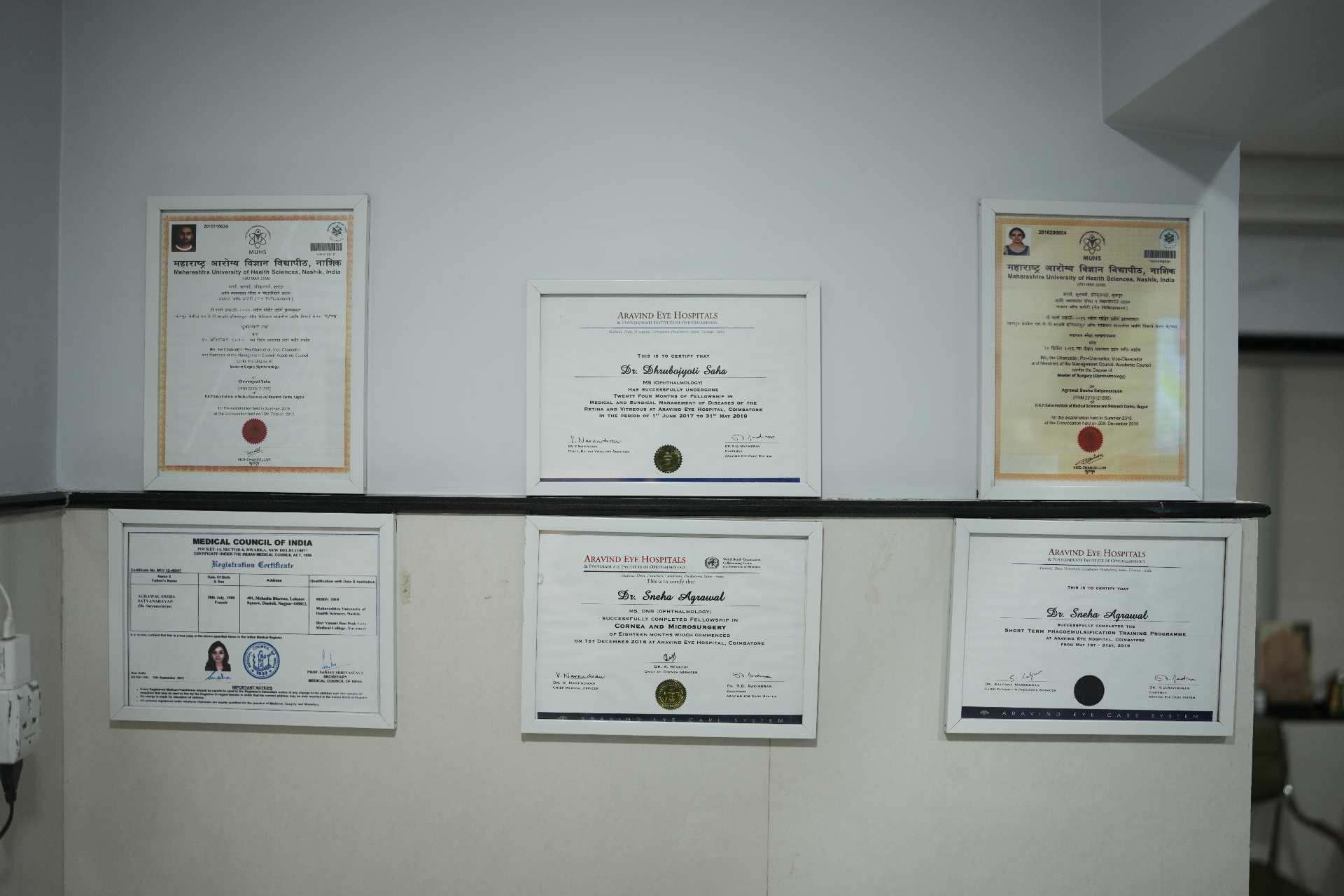 Framed degrees and fellowship certificates of Dr. Dhrubbojyoti Saaha, Dr. Sneha Agrawal and Dr. Gunjan Rathi Kelkar displayed at Total Retina Eye Care, Nagpur